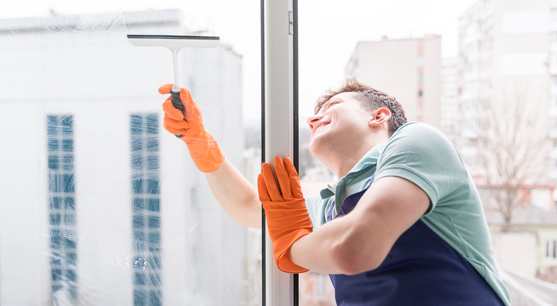 Mann reinigt ein Fenster